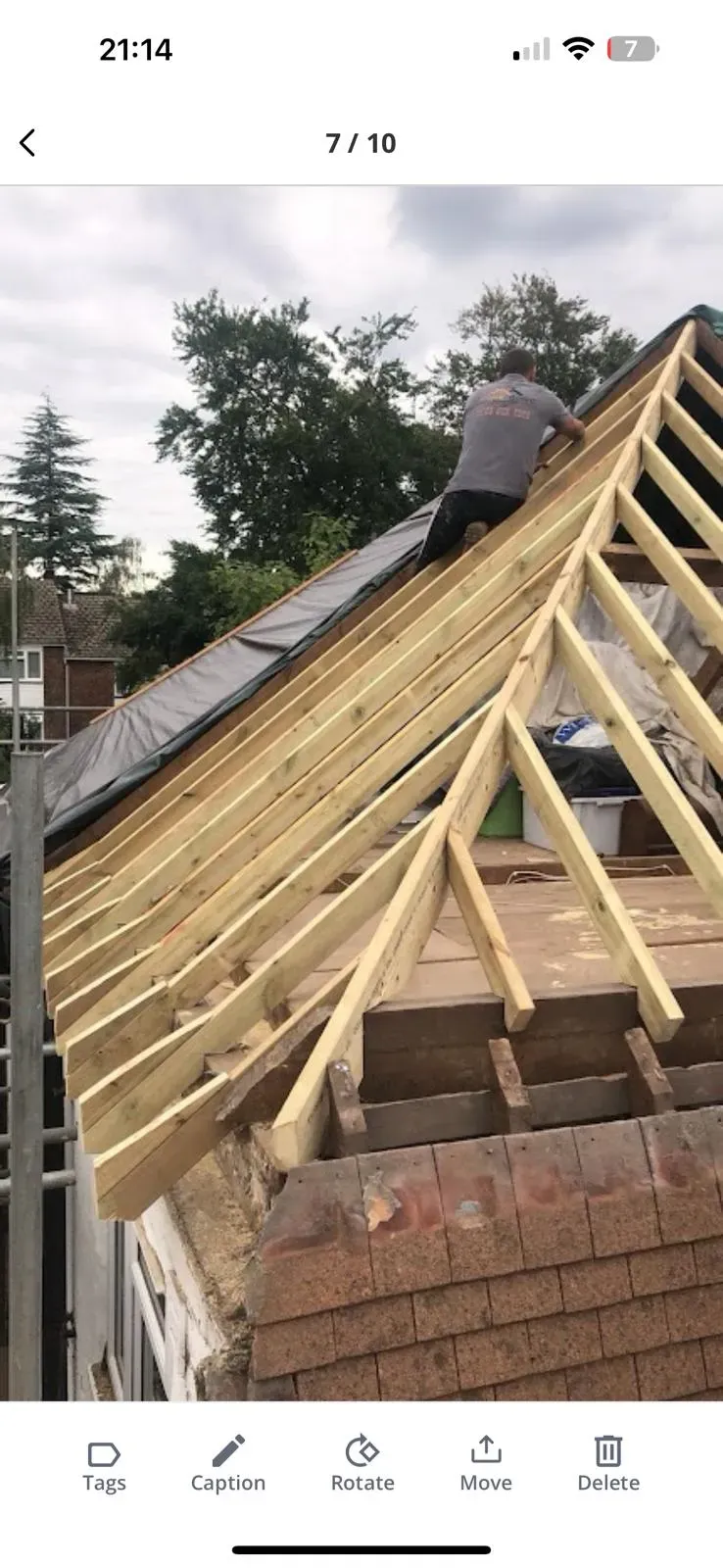 Roofer installing new roof timber frame with rafters and membrane.